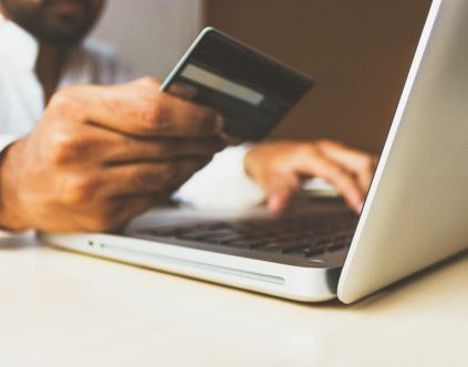 Man using a credit card to purchase something online.